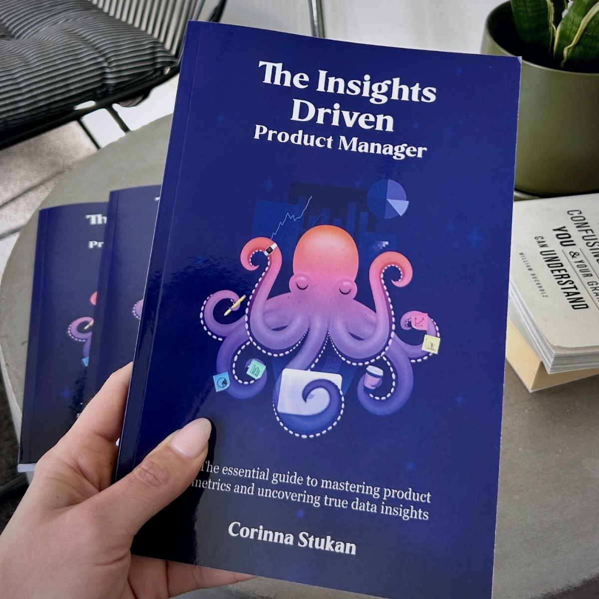 Corinna holding her book, The Insights Driven Product Manager